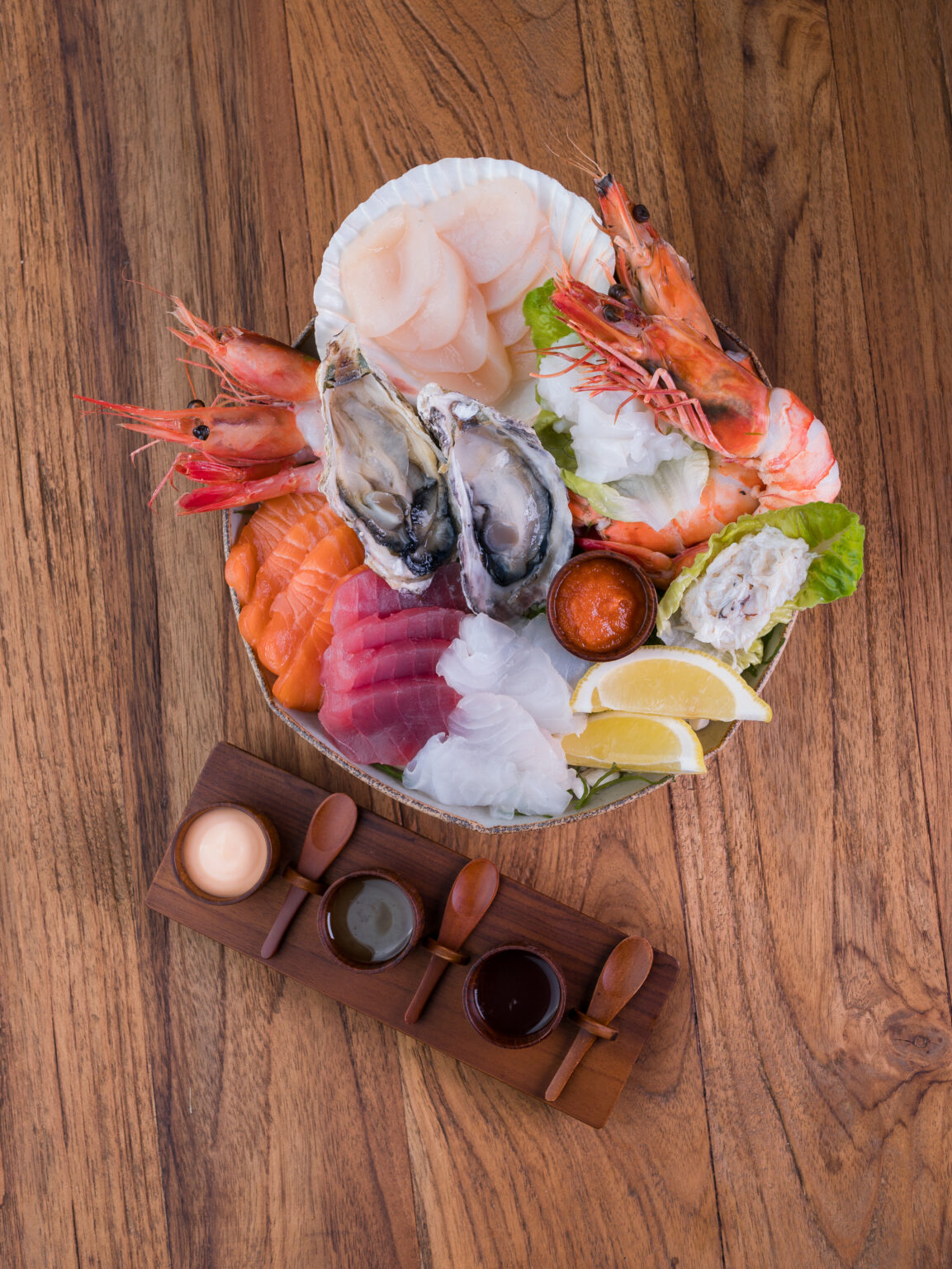 Platter of fresh oysters, prawns and raw fish served on ice for sharing