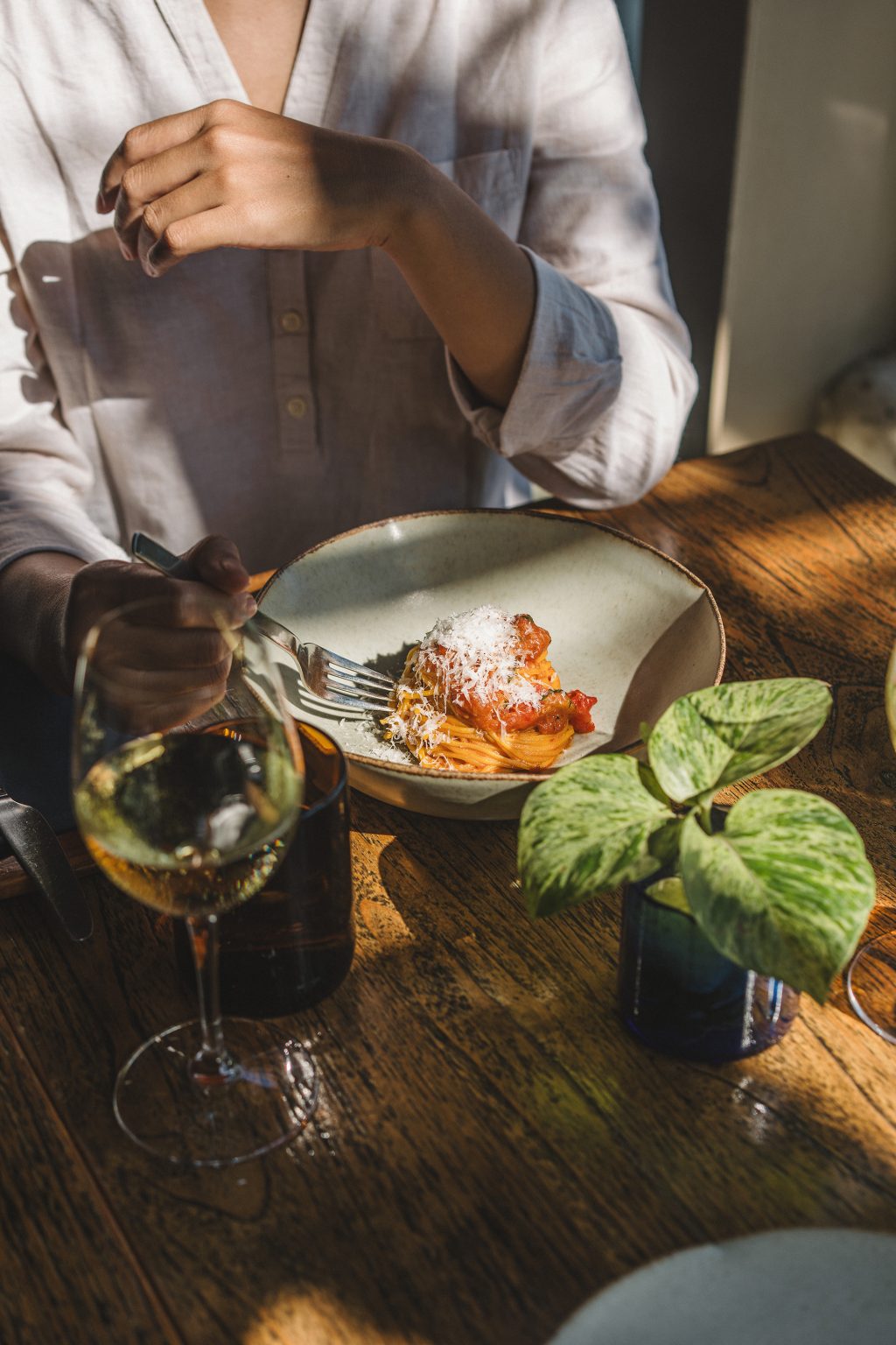 Plated seafood main course with herbs served alongside a glass of white wine