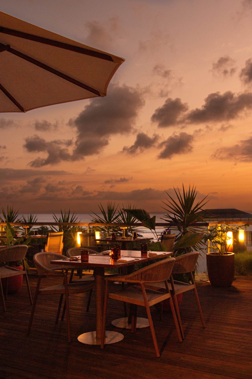Rooftop tables glow under an orange sunset, the heart of seafood Seminyak dining